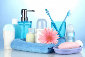 Assortment of bathroom supplies and pink flower.