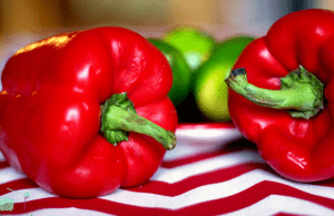 Two red peppers on red and white cloth.