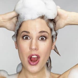 Surprised woman with soap in her hair.