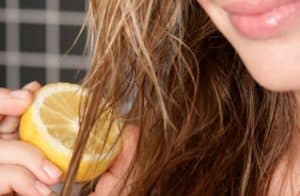 Woman putting lemon on her hair.
