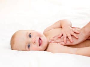 Baby smiling on a bed.