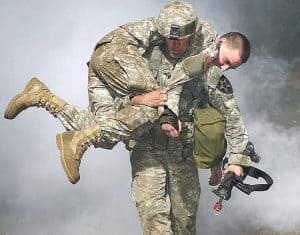 Soldier carrying another soldier on his back.