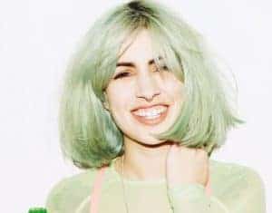 Green-haired woman smiling. 