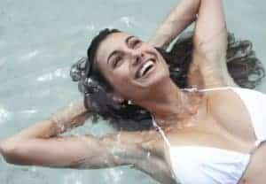 Woman smiling while floating on her back in water.