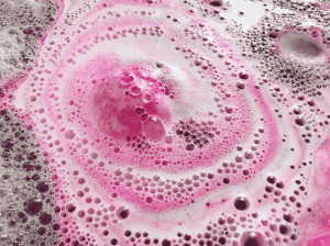 Lush's pink bath bomb in water.