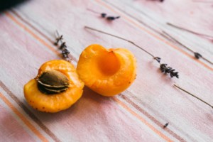 Apricot cut in half on wooden table.