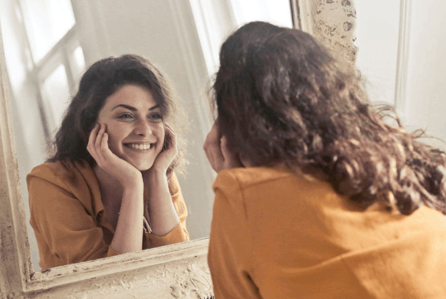 Woman smiling in the mirror.