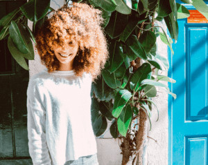 Woman with voluminous hair smiling. 