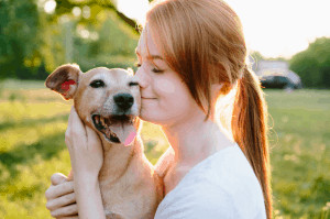 Women Kissing Her Pet Dog.