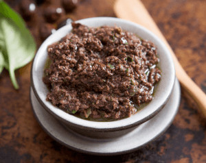Bowl of brown olive spread.