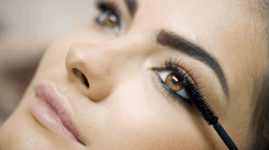 Woman applying mascara.