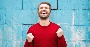 Man smiling with eyes closed and pumping fists.