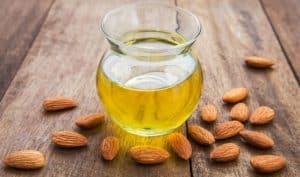 Almond oil and scattered almonds.