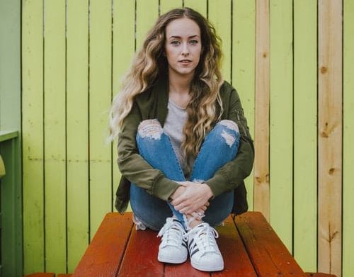 Girl sat on bench table. 