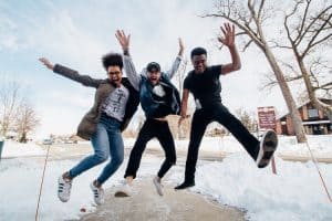 Three people jumping in the snow. 