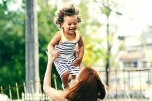 Woman lifting laughing child.