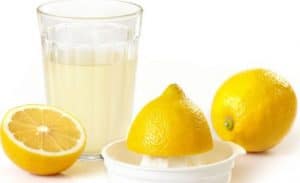 Halved lemons and a cup of lemon juice.