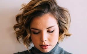 Woman with short hairstyle looking downward.