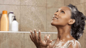 Woman looking up in the shower. 