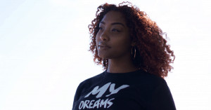 Woman with curly hair looking into the distance. 