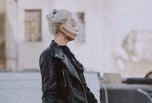 Side profile of woman with leather jacket walking.