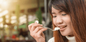 Woman eating with a spoon. 