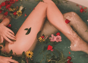 Womans legs with flowers in bath