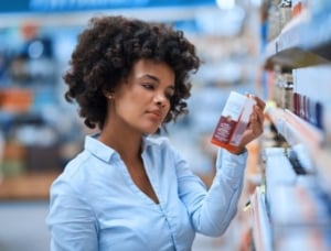 Woman reading supplement label.