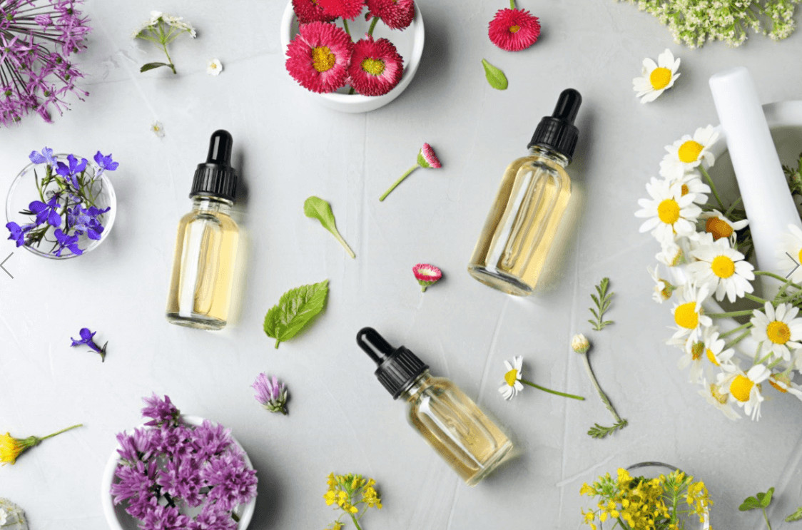 Birds eye view of essential oil bottles and flowers.