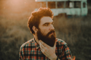 Man with beard looking to the side.