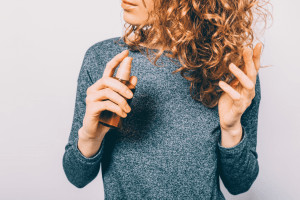 Woman spraying curly hair.