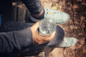 Birds eye view of hand holding glass of water.