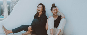 Two women sitting and laughing. 