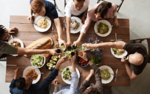 Friends clinking glasses while dining together.