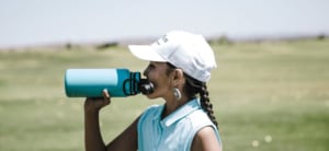 Profile of woman drinking from a reusable water bottle.